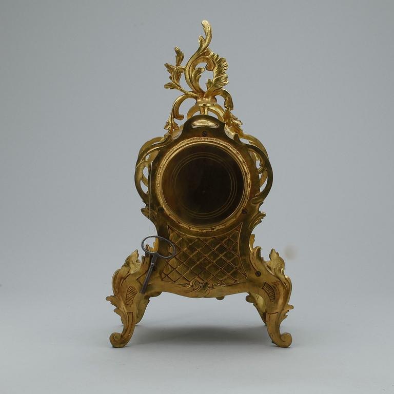 GARNITYR MED BORDSPENDYL OCH ett par KANDELABRAR, mässing, Louis XV-stil, troligen omkring 1900.