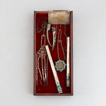 A box with nail covers, cigarett holders, a card, a pendant and some tools, China, circa 1900.