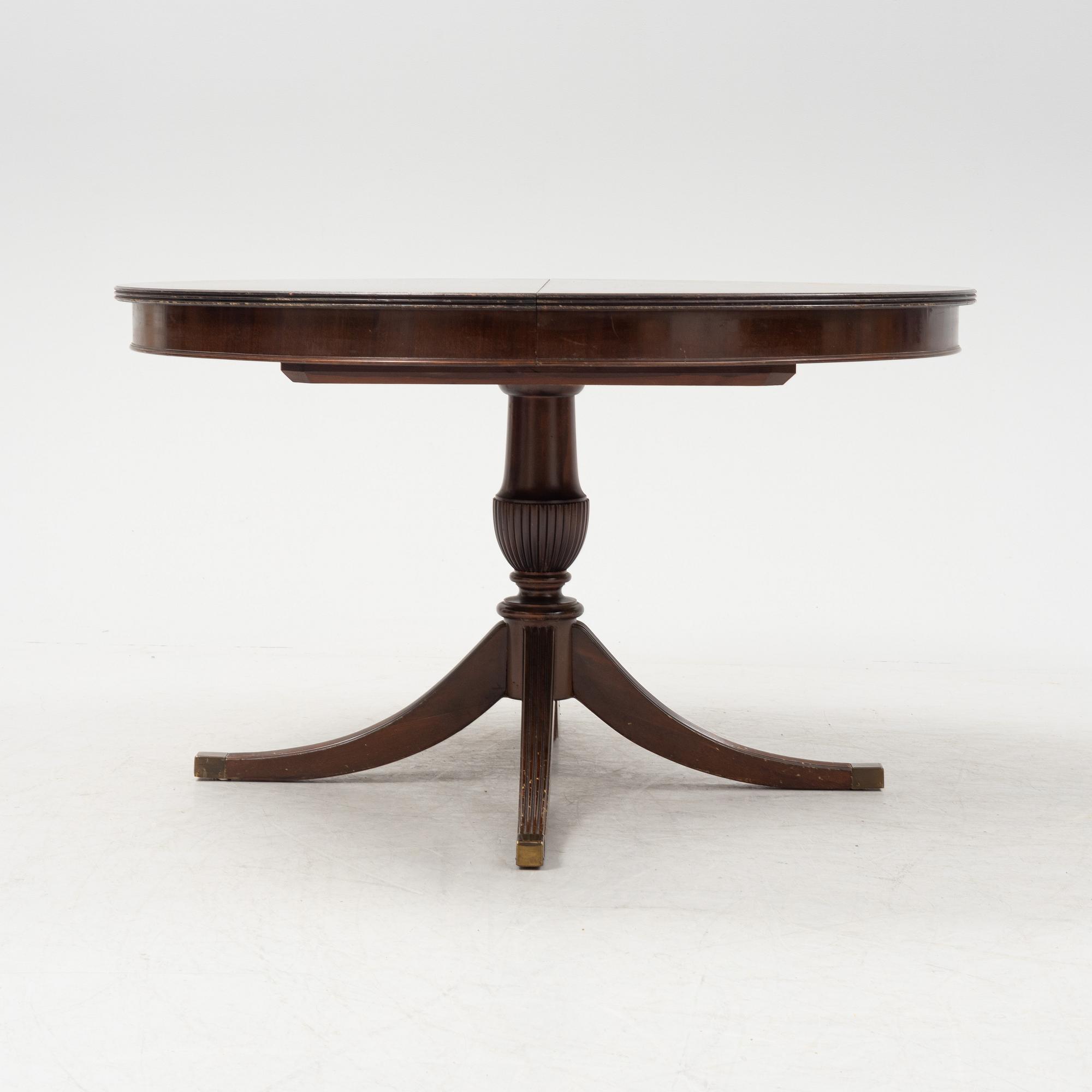 A round mahogany dining table with three additional leaves.