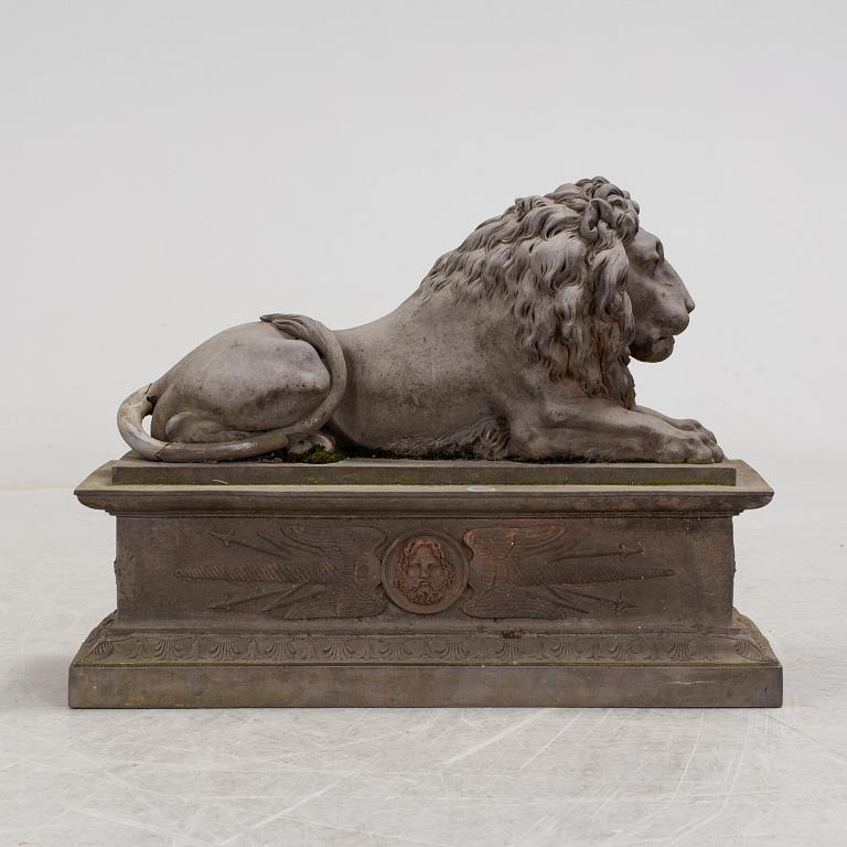 A SCULPTURE/ DECOR-ELEMENT, a lion on a plint, artificial stone, empire-style, late 1900s.