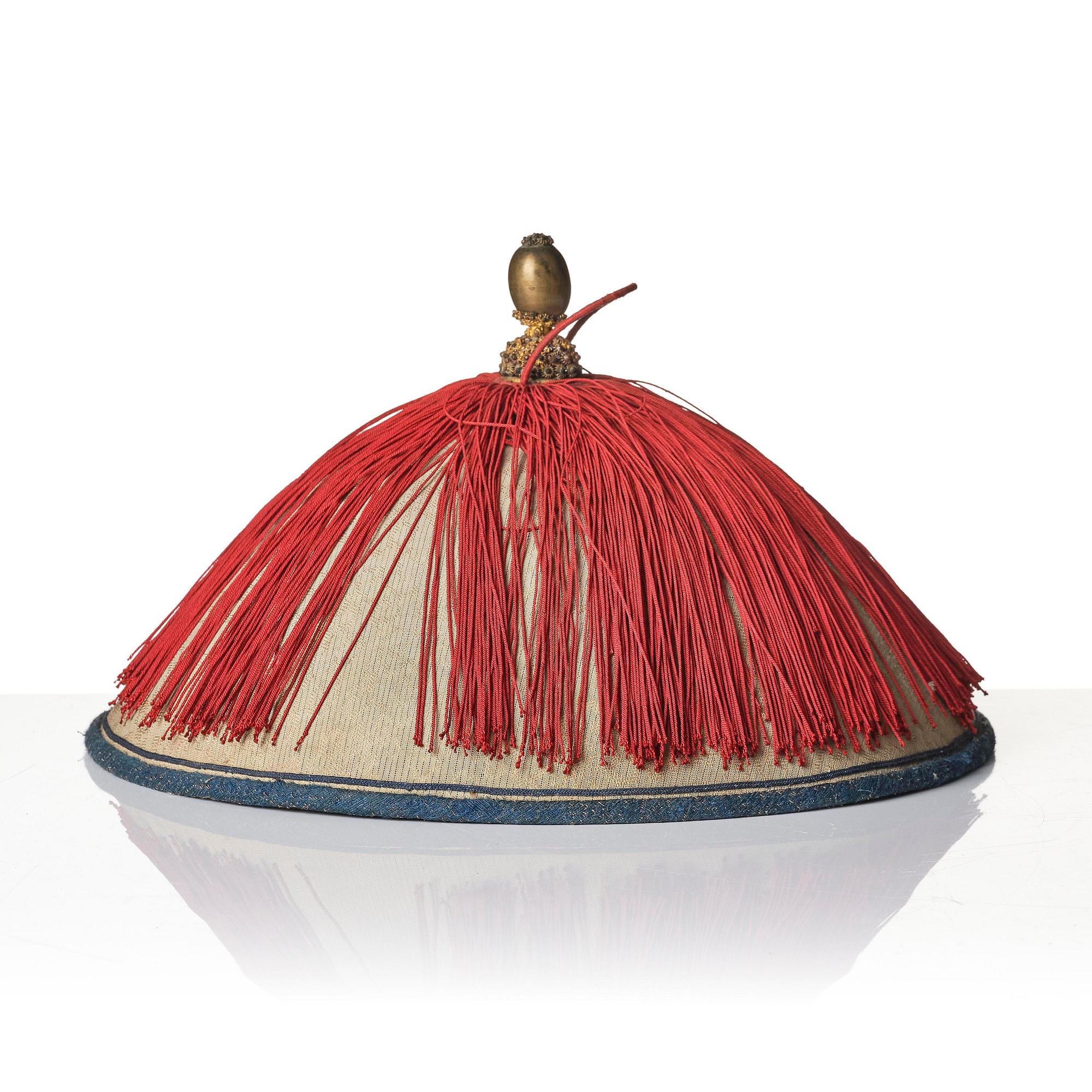 Two boxes with a mandarin's summer hat and black satin autumn hat and feather with six mandarin hat insignias.