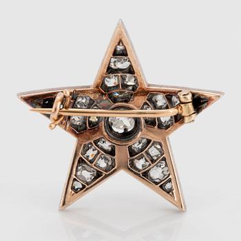 A 14K gold and silver star brooch set with old-cut diamonds.