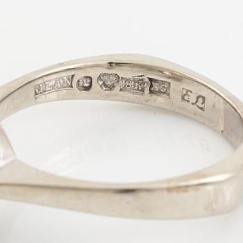 An 18K white gold ring set with a round brilliant-cut diamond.