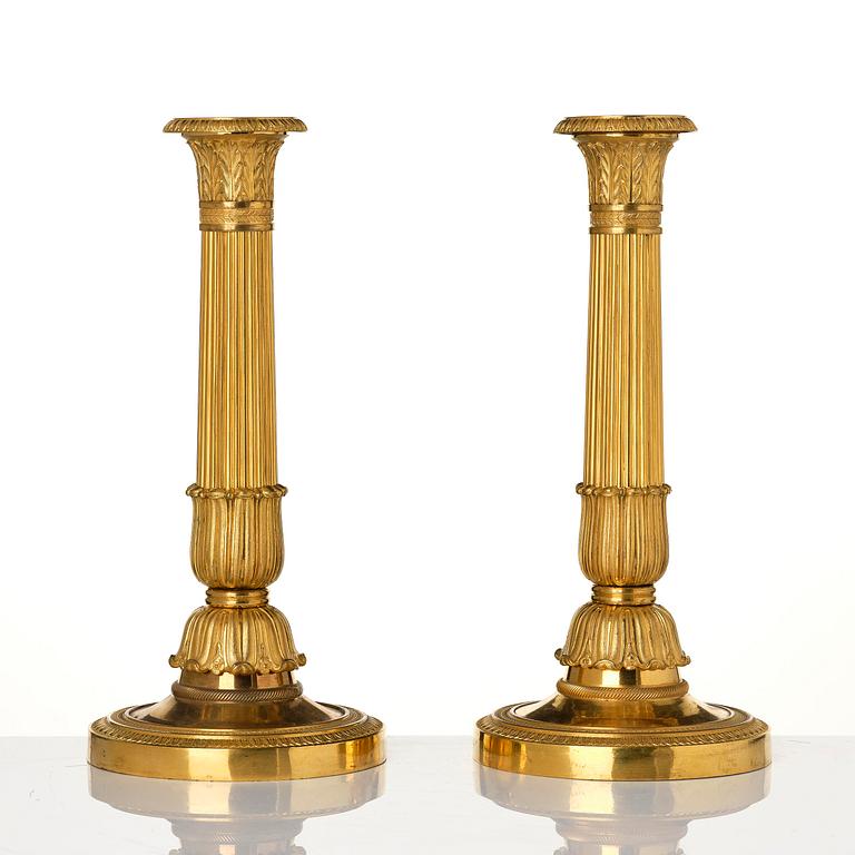 A pair of French Empire gilt-bronze candlesticks, early 19th century.