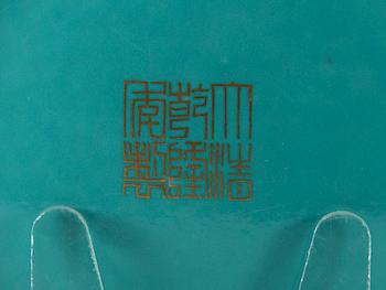 A turquoise glazed slip decorated dish, presumably late Qing dynasty with Qianlong seal mark in gold.