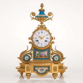 A mid-19th-century French gilt-brass mantel clock with a pair of candelabra by Dussault.