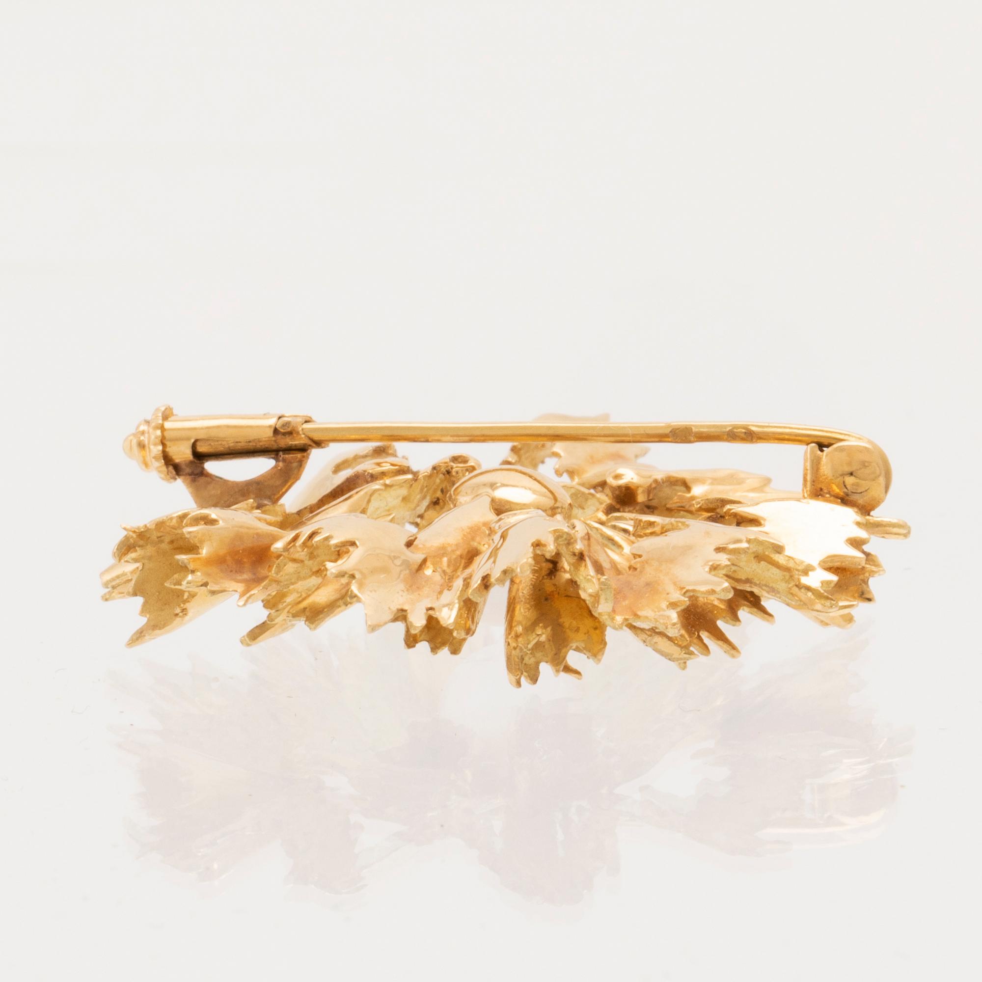 An 18K gold brooch set with a cultured pearl.