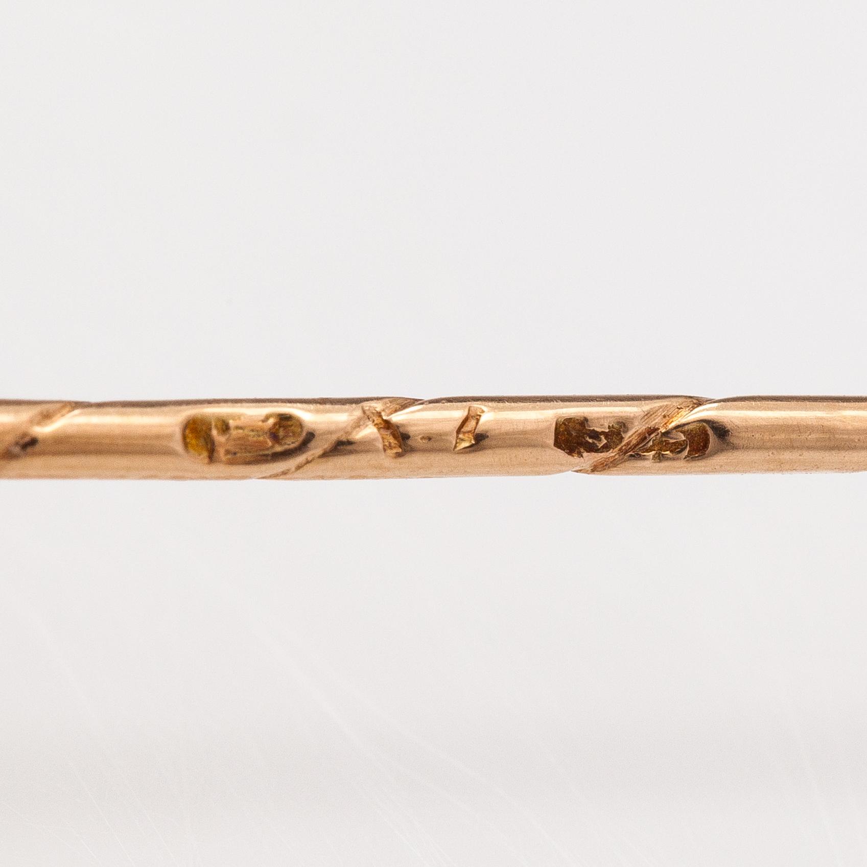 A 14K gold tiepin with a aquamarine.