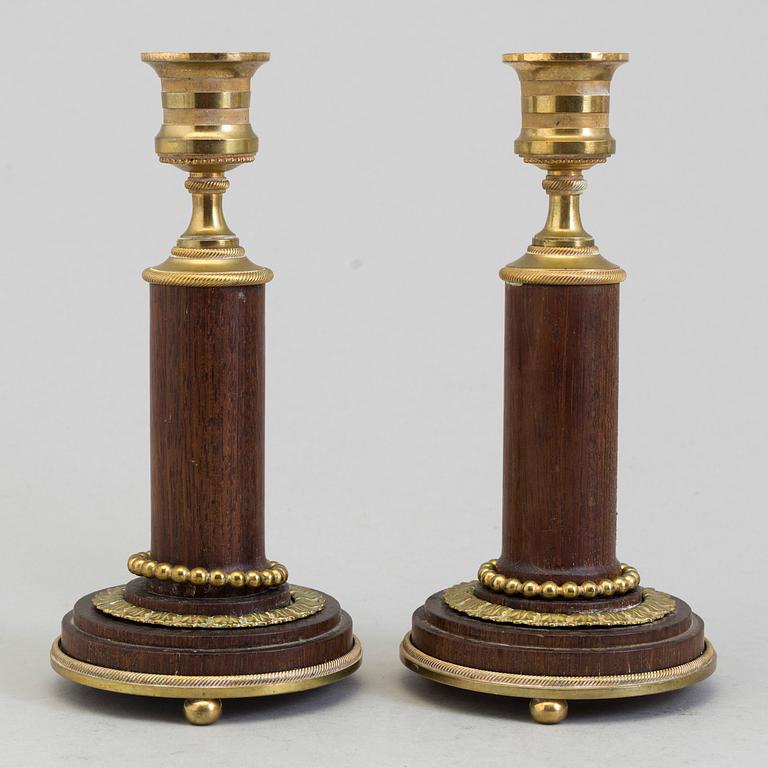 A pair of 20th century mahogany and brass candlesticks.