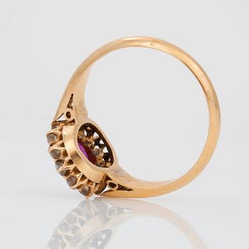 A ring set with oval, mixed-cut, untreated ruby surrounded by old cut diamonds.