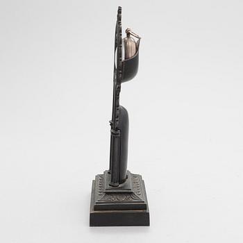 A neo-gothic cast iron pocket watch stand with a pocket watch. 19th century.