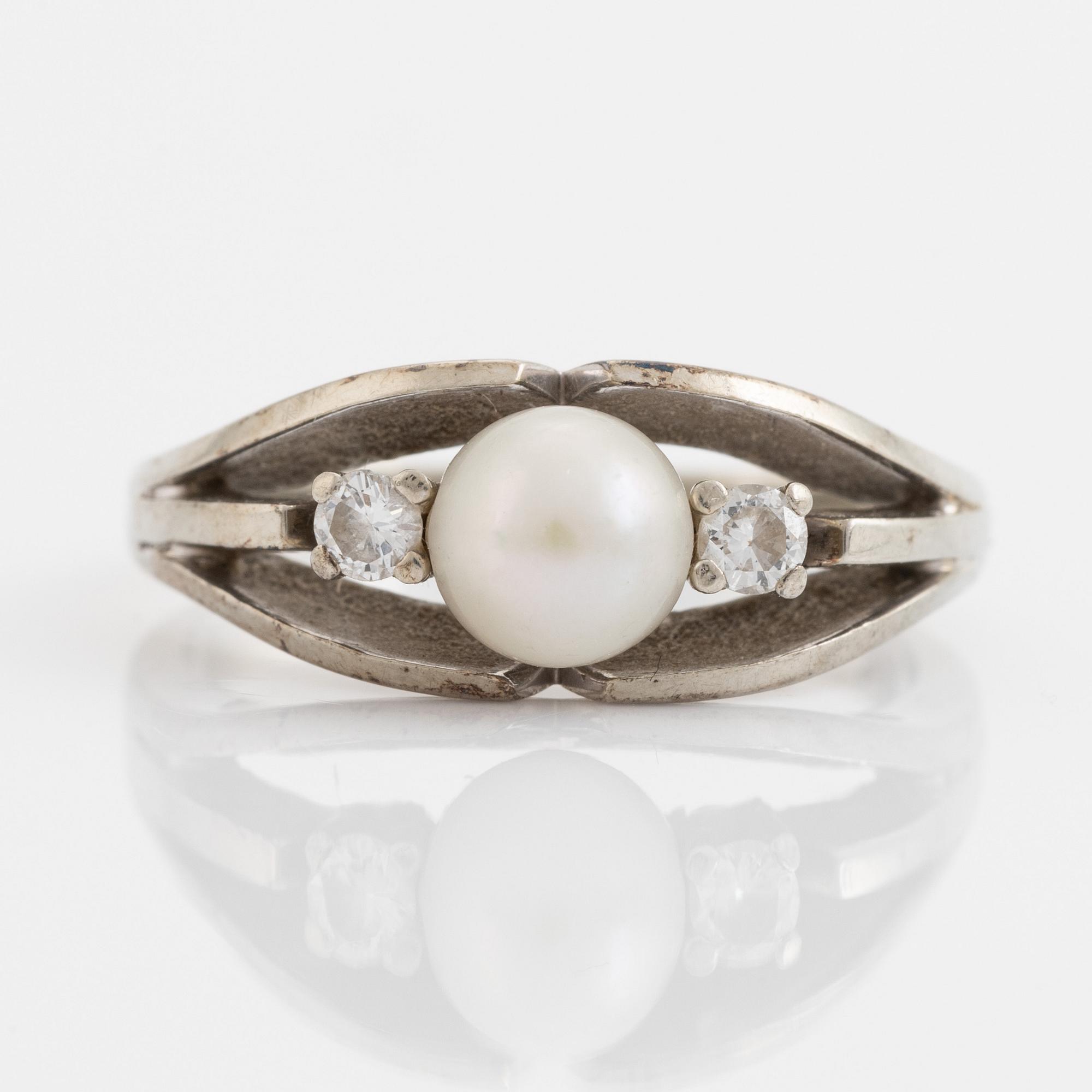 Ring med pärla och två briljantslipade diamanter.