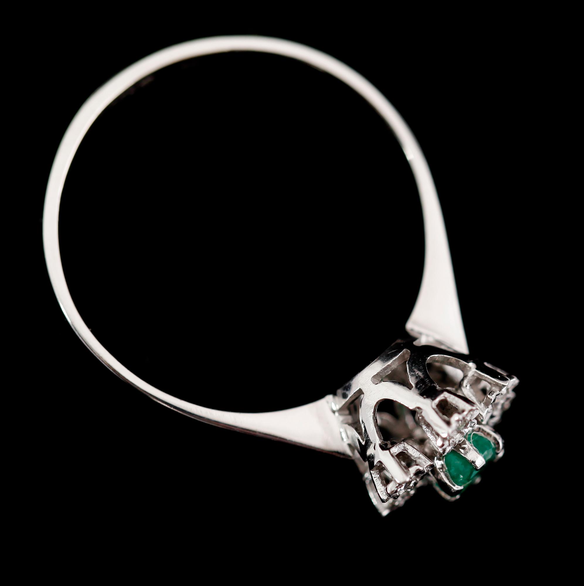 RING, 18 k vitguld, smaragd och 6 mindre briljantslipade diamanter.