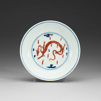 1626. A blue and white dish with a red four clawed dragon, Qing dynasty (1644-1912), with Yongzheng six character mark.