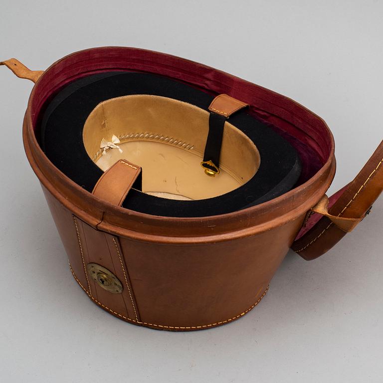 A hat box with a top hat and leather gloves, first half of the 20th century.