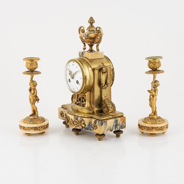 A pair of candelabras and a mantel clock, Louis XVI-style, circa 1900.