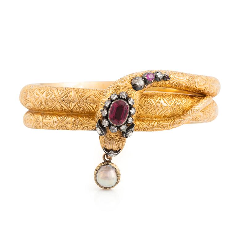A Victorian snake bracelet in 14K gold with rose-cut diamonds, red stones and a half pearl.