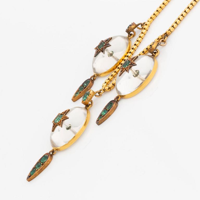 A Victorian 18K gold necklace with rock crystal set with green stones, possibly emeralds. Around 1880.