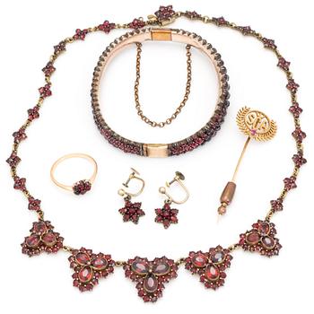 Five pieces of jewellery with facetted garnets.