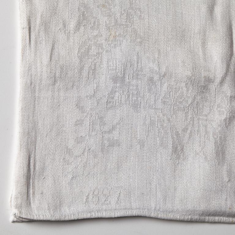 A TABLE CLOTH AND NAPKINS, 24 pieces, linen damask, the table cloth is dated 1827, ca 560-567 x 207,5 cm, Sweden 1827.