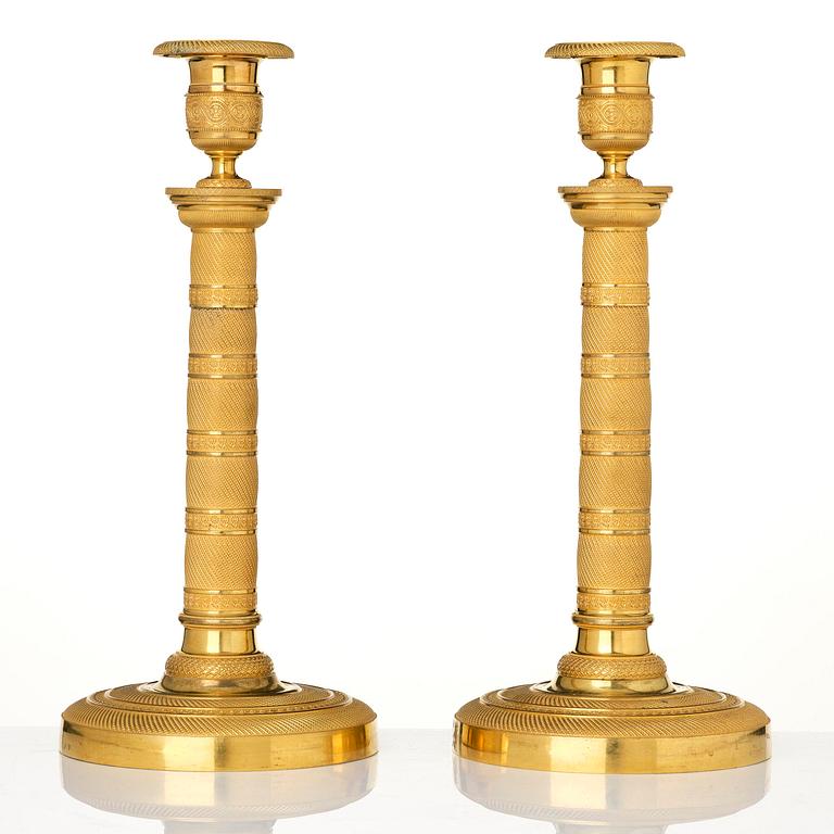 A pair of French Empire gilt-bronze candlesticks, early 19th century.