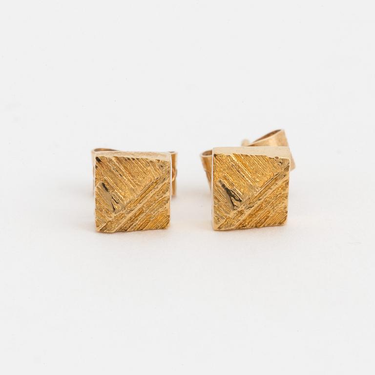 A pair of earrings with a textured surface.