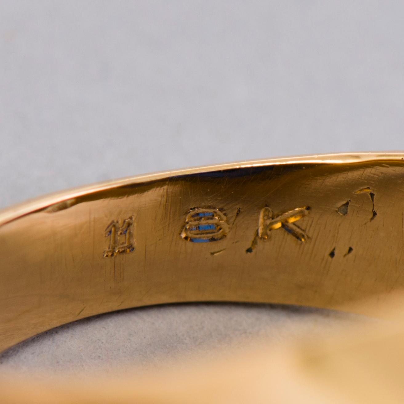 A gold 18K Freemason ring with a synthetic blue sapphire.