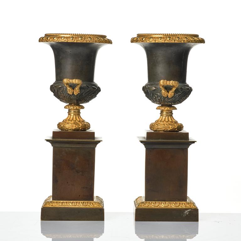 A pair of French Louis Philippe gilt and patinated bronze urns, first part 19th century.