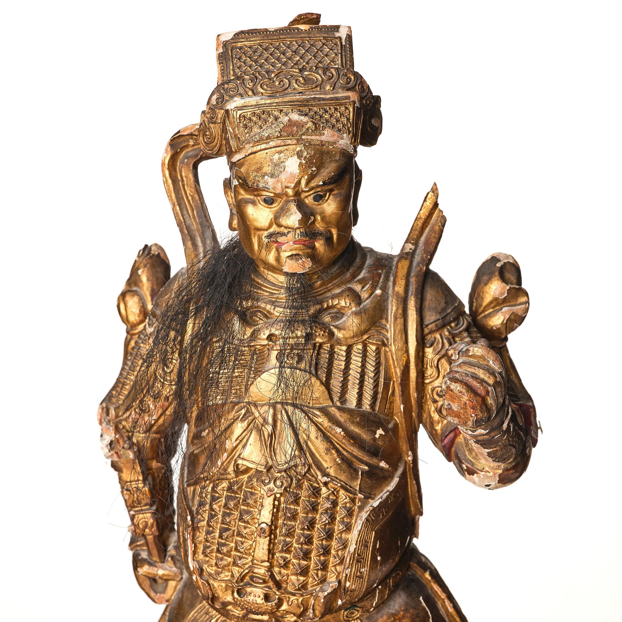 A gilt and lacquered standing figure of a guardsman, Qing dynasty.