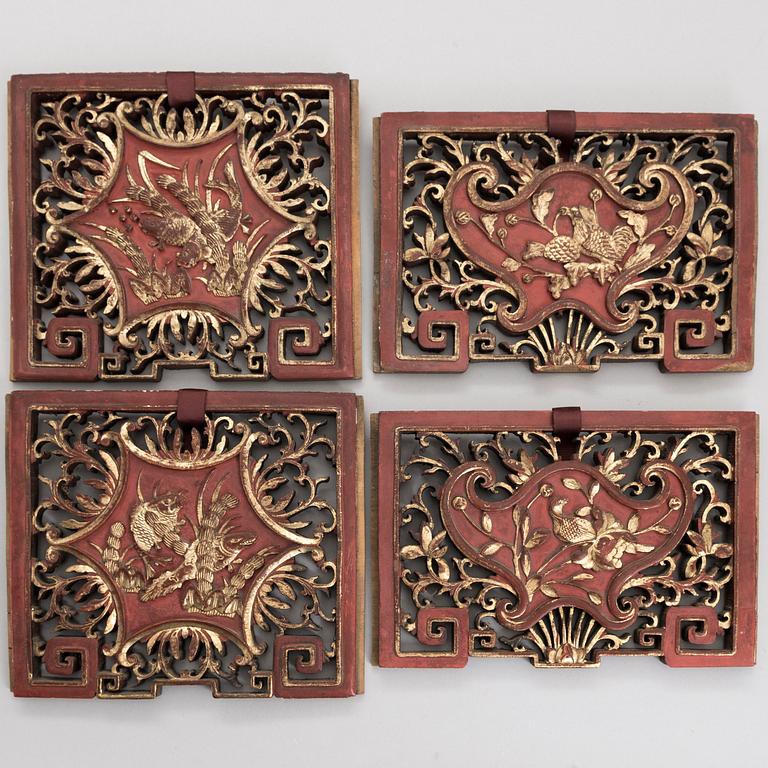 A set of four Chinese gilt and painted wooden decorations.