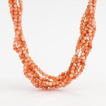 A 6-strand pearl collier with coral pearls and an 18K gold clasp.