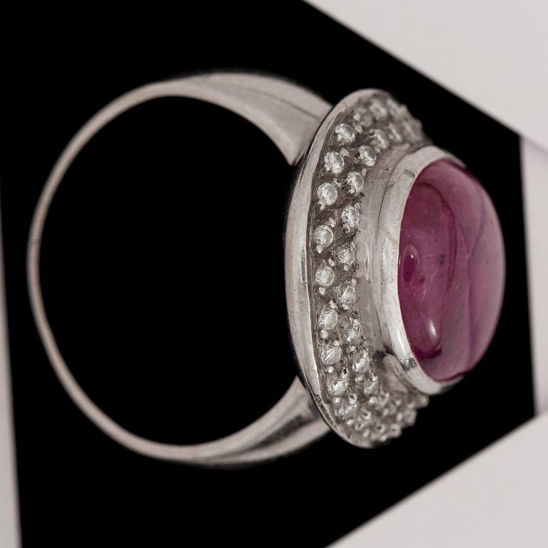 RING, 18k vitguld med cabochonslipad rubin med dubbel krans av briljantslipade diamanter, tot. ca 0.75 ct. vikt 12g.