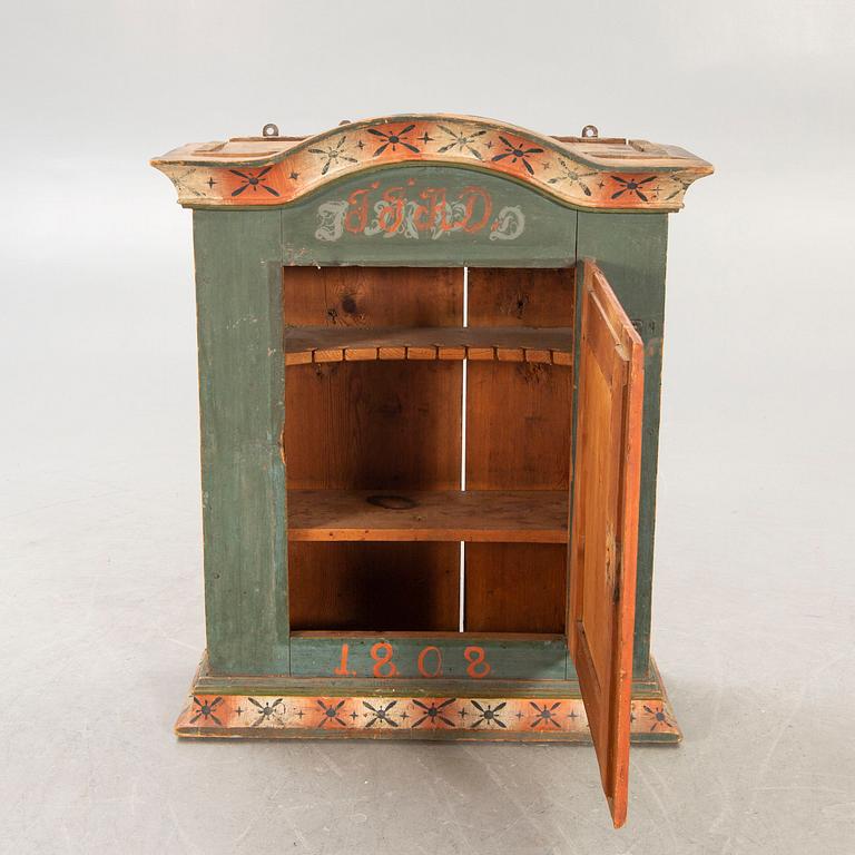 A painted Swedish wall cabinet dated 1808.