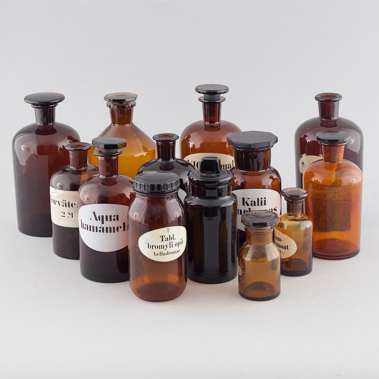13 pharmacy bottles in mainly glass, first half of the 20th century.