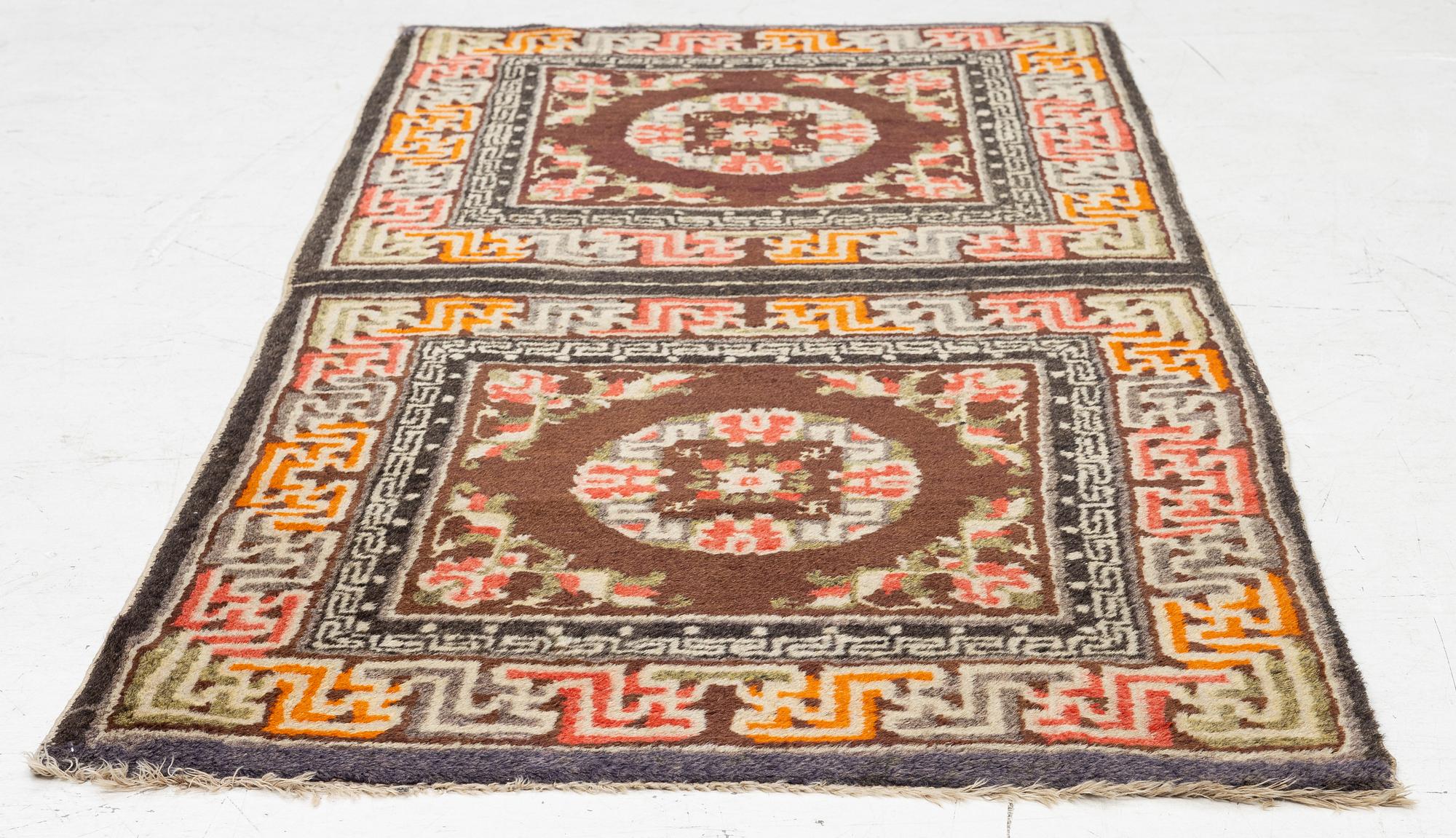 A Chinese two square rug, antique, c. 142 x 71 cm.
