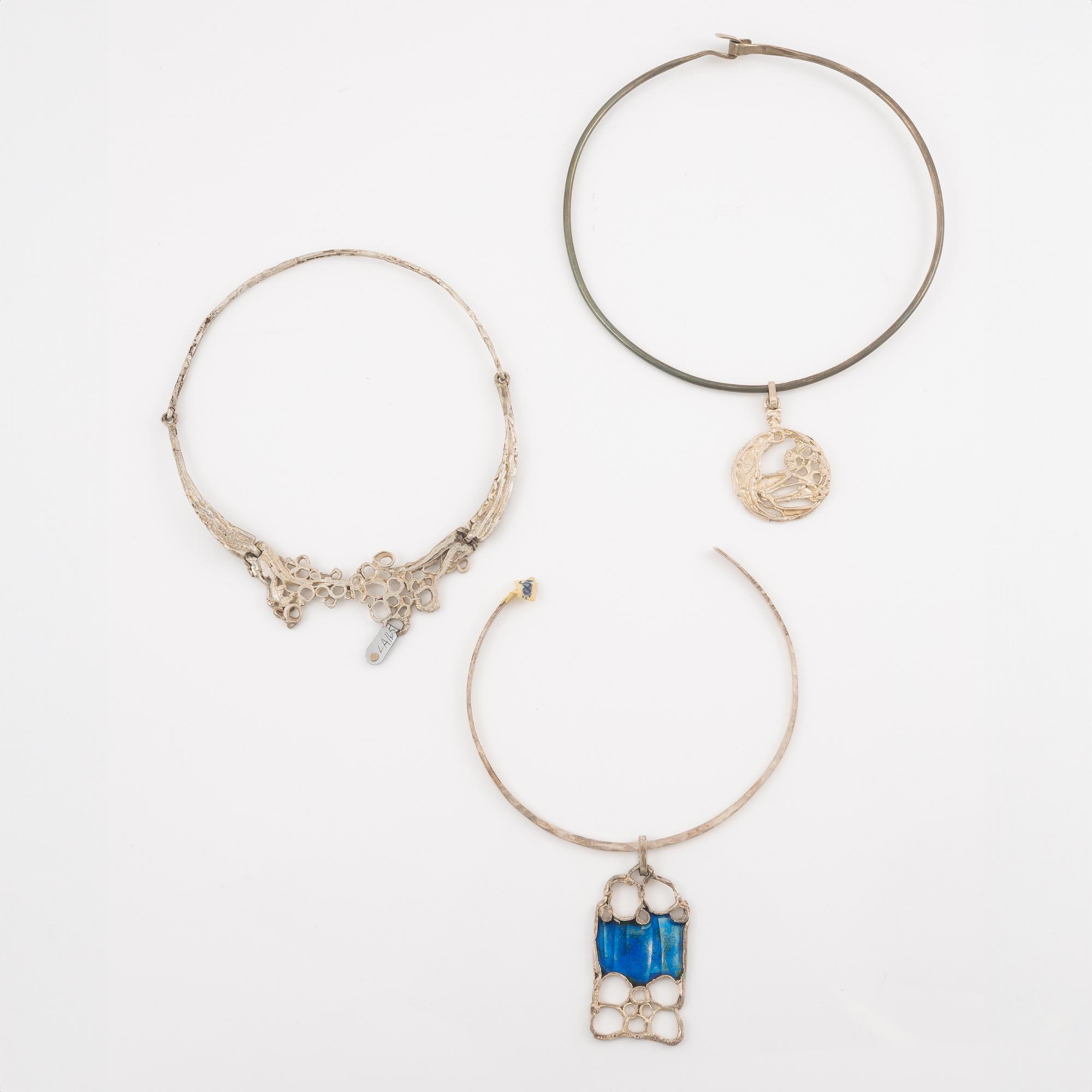Lars Arby, three neck rings and two pendants, silver with enamel.