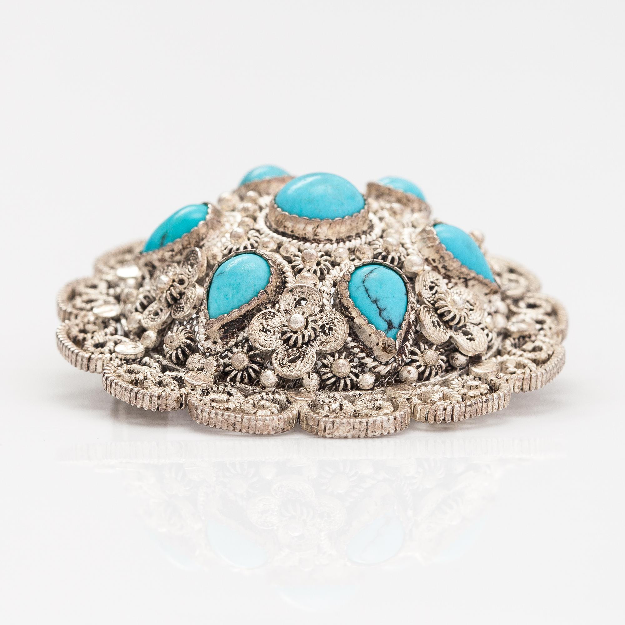 A silver bracelet and ring with turquoises. China.