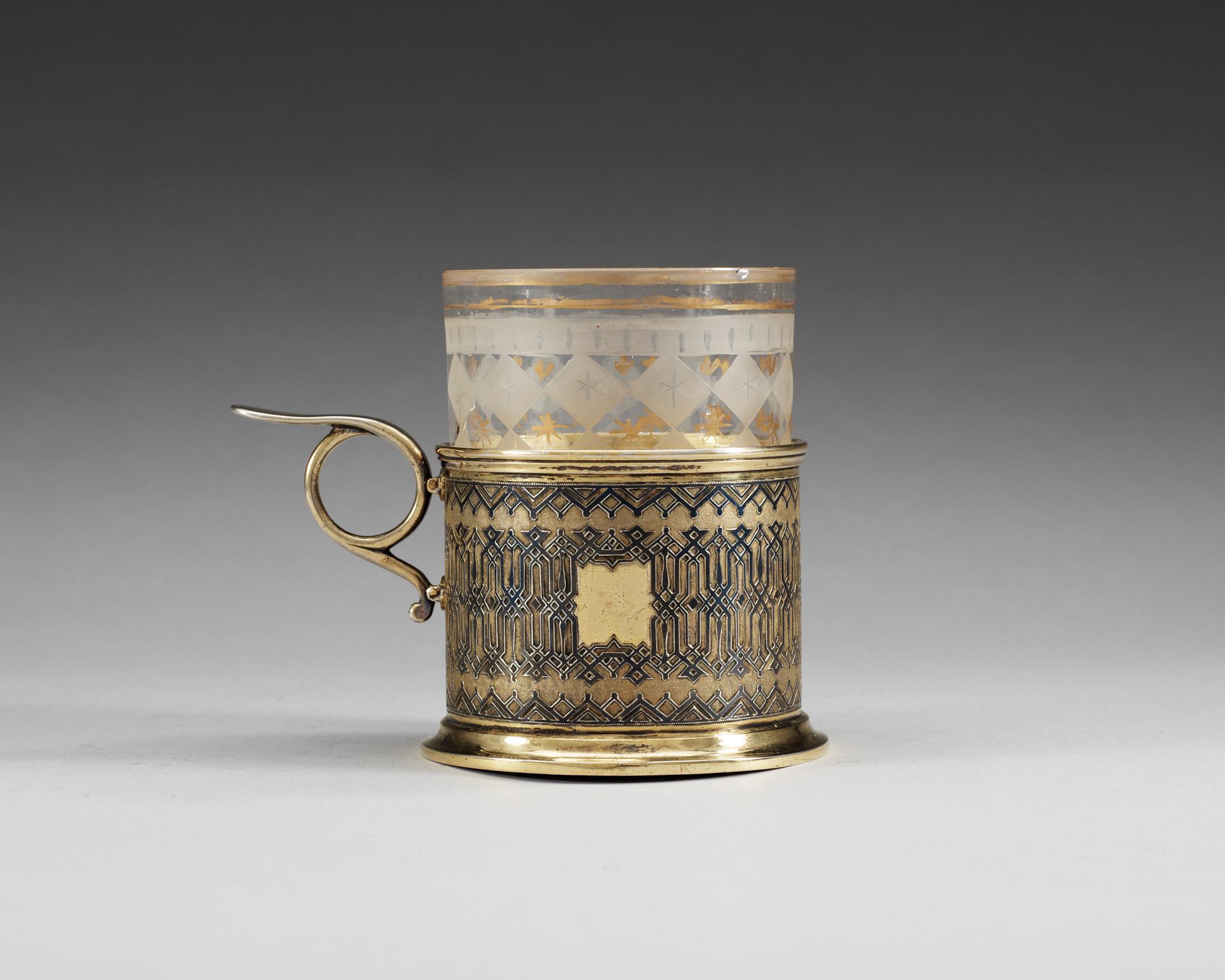 A RUSSIAN SILVER-GILT AND NIELLO TEA GLASS-HOLDER, unidentified makers mark, Moscow 1872.