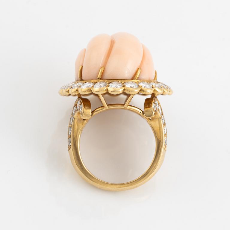 An 18K gold and coral Cartier ring set with round brilliant-cut diamonds.