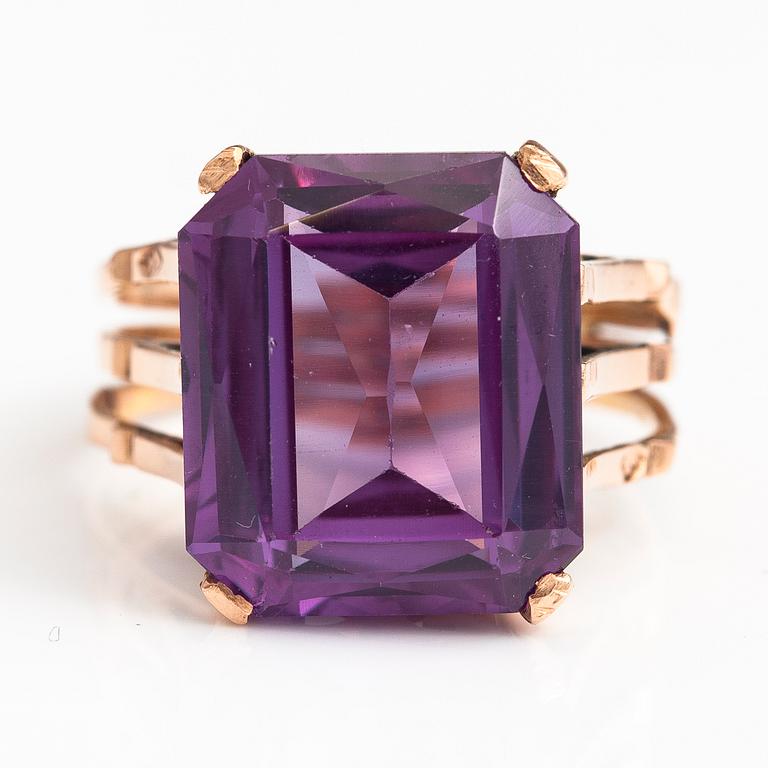 A 9-14K gold ring with a synthetic sapphire.