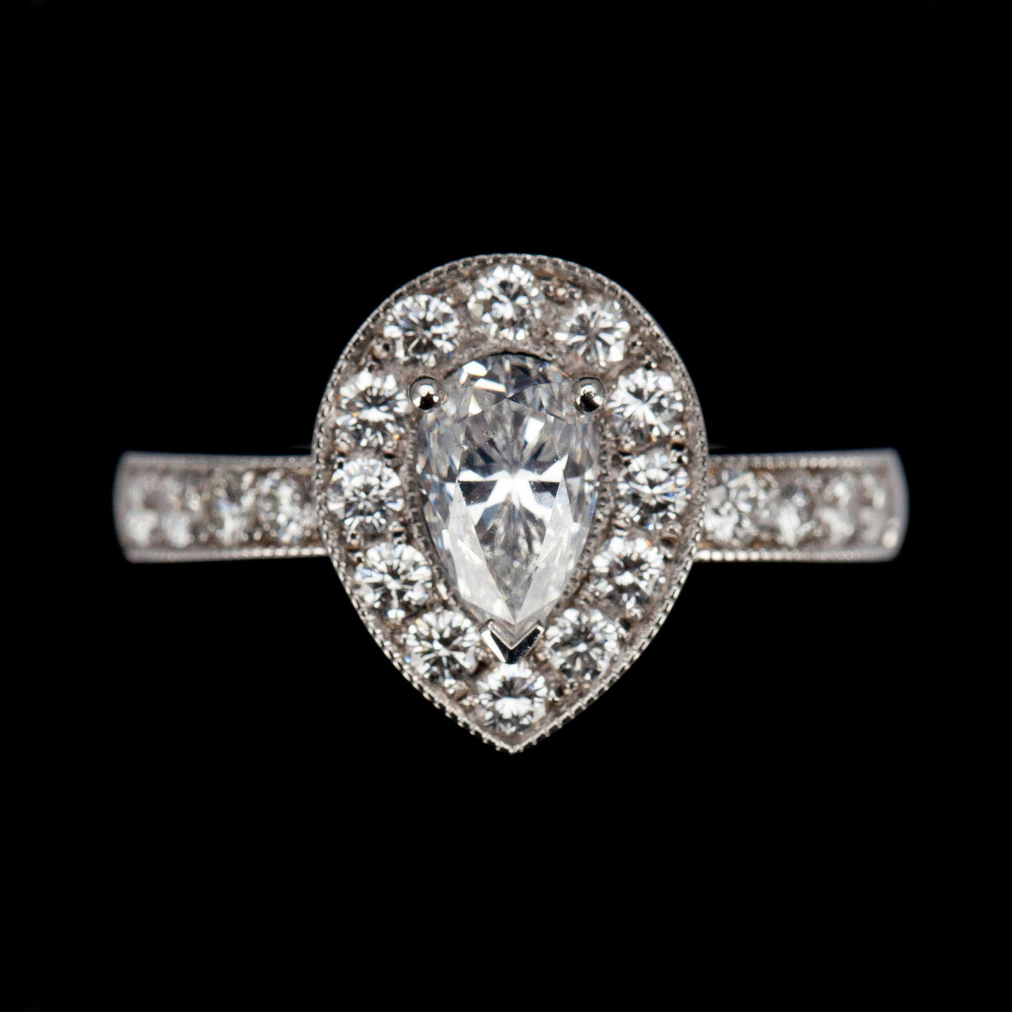 RING, vitguld 18K, mittstenen droppslipad diamant 1,01ct, sidostenar tot. 0,65ct. G/VS. Intyg 220.