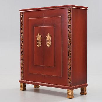 A red lacquered cabinet with carved and bronzed decoration 'à la chinoise', by Otto Wretling, Umeå, Sweden 1930's.