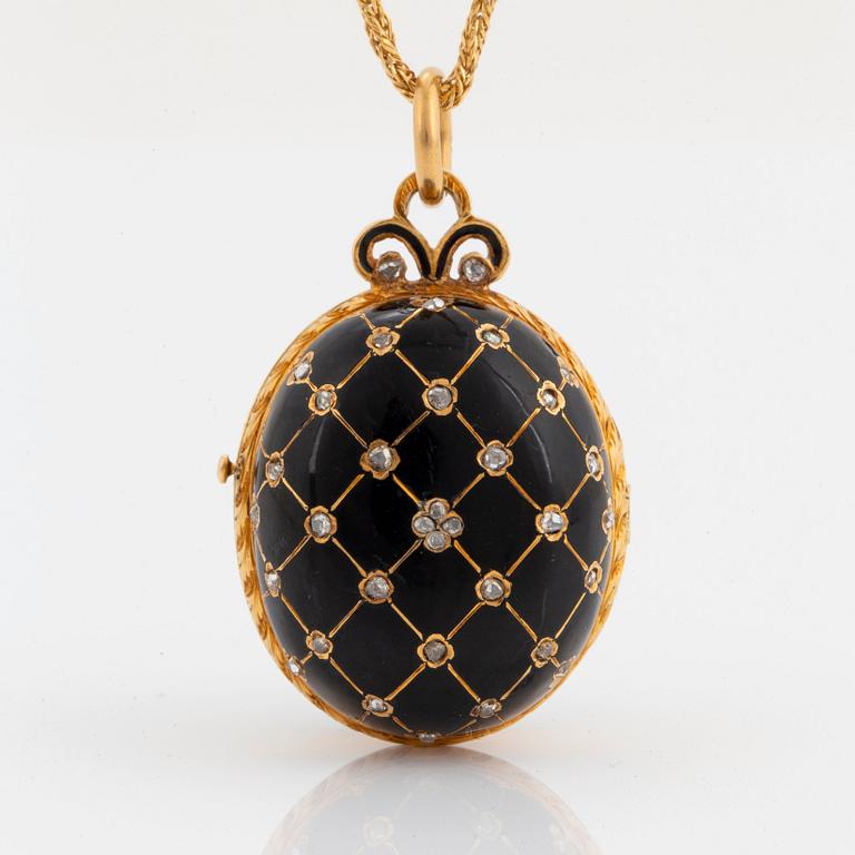 An egg shaped locket in 18K gold and black enamel set with rose-cut diamonds and rubies.