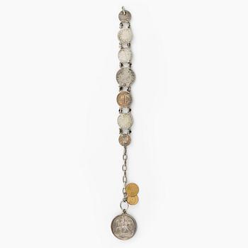 Two bracelets, a brooch, and a pendant with coins.