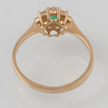 RING, 18K guld med fasettslipad smaragd samt 10 briljantslipade diamanter ca 0.10 ct,  importstämplad. Vikt 2,4 gram.