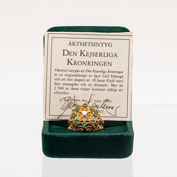 An 18K gold ring set with a round brilliant cut diamond and round single cut emeralds by Franklin Mint 1980.