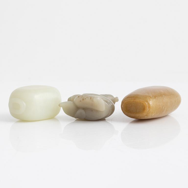 Two snuff bottles and a figurine, nefrit and green stone, China, 20th century.