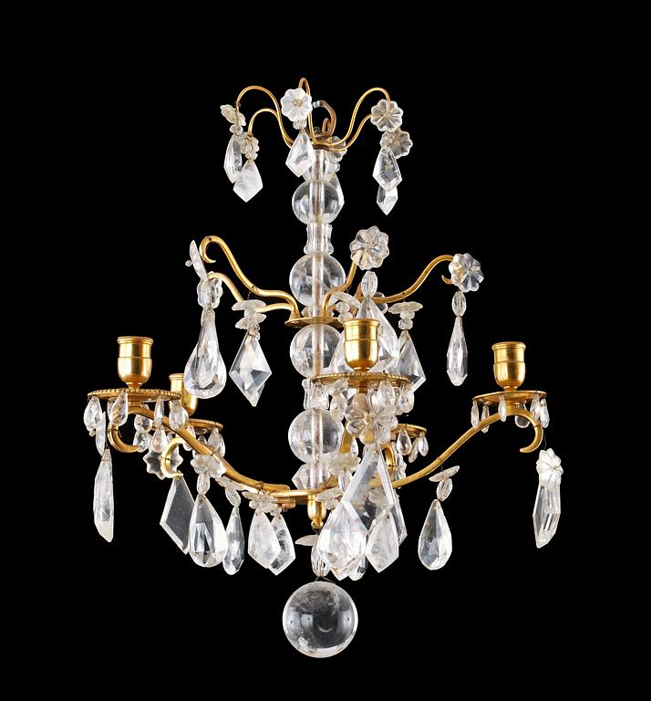 A pair of Baroque style four-light rock crystal chandeliers.