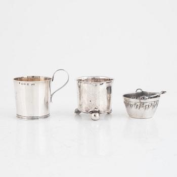 A silver beaker, a cup, a tea strainer and a sugar spoon, including Jacob Richard Bergh, Gävle 1845.