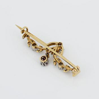 BROSCH, 18K guld med runda fasetterade rubiner, tot ca 0,40 ct och små rosen och gammalslipade diamanter. Vikt ca4,48 g.